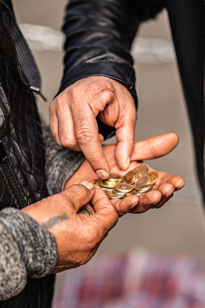 Home Detailed shot of hands exchanging coins, illustrating financial transactions.
