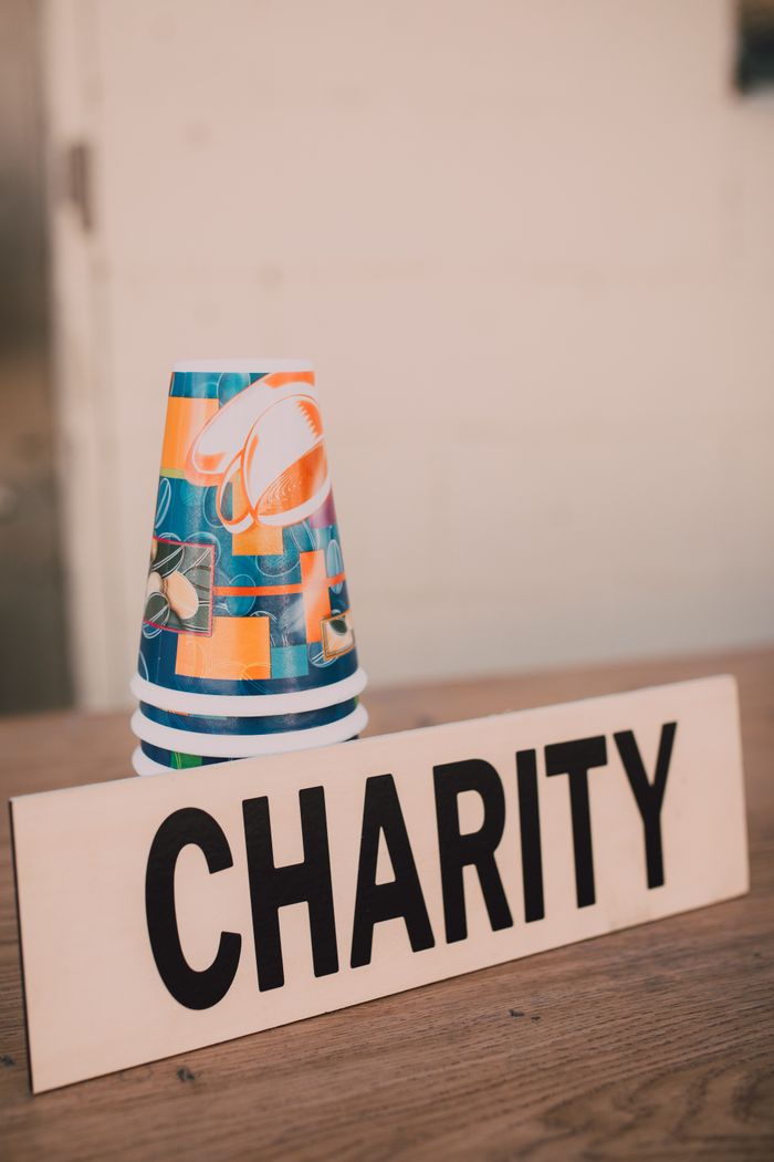Home Stacked paper cups and a charity sign symbolizing donations and giving back.